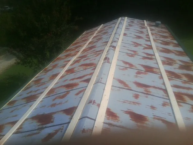 Rusted metal roof panels with new wood purlins before replacement — Storm Damage Roof Repair in East Baldwin by Roofing Brothers