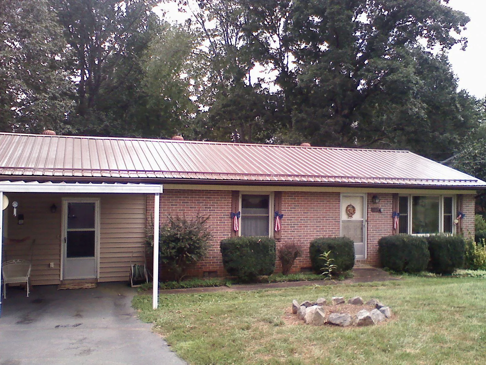 Bronze metal roof and carport on a brick ranch home — Roof Repair work by our crew in East Baldwin